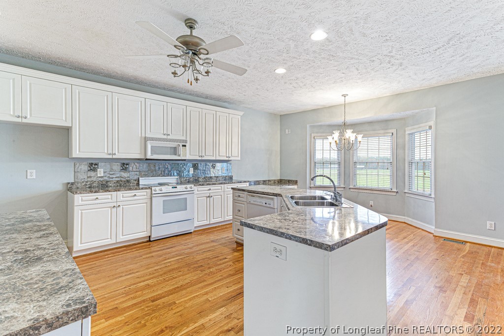 4051 Mt Tabor Road Red Springs, NC 28377 - Photo 17 of 50 a kitchen with granite countertop white cabinets and white appliances