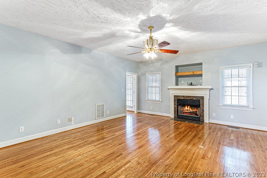 4051 Mt Tabor Road Red Springs, NC 28377 - Photo 22 of 50 a view of an empty room with wooden floor fireplace and a window