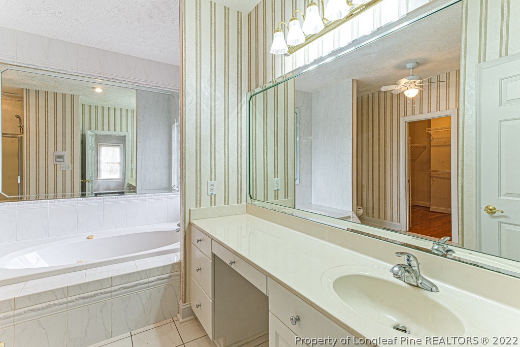 4051 Mt Tabor Road Red Springs, NC 28377 - Photo 31 of 50 a bathroom with a tub sink and mirror