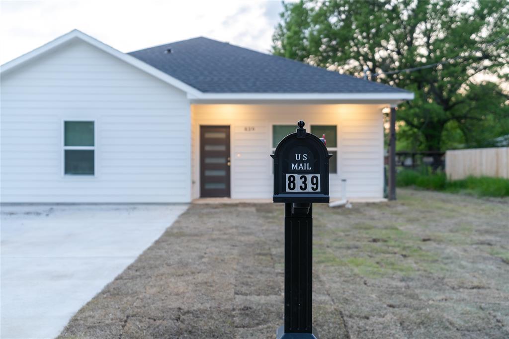 View of front of home featuring fence and roof with shingles