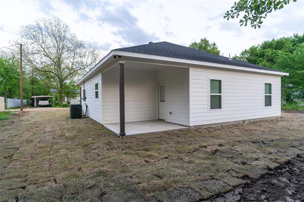 839 Southwest 7th Street Cooper, TX 75432 - Photo 13 of 21 Back of property featuring central AC unit and a patio