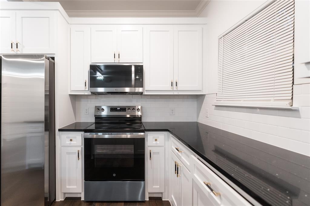 839 Southwest 7th Street Cooper, TX 75432 - Photo 19 of 21 Kitchen with appliances with stainless steel finishes, dark countertops, and white cabinets