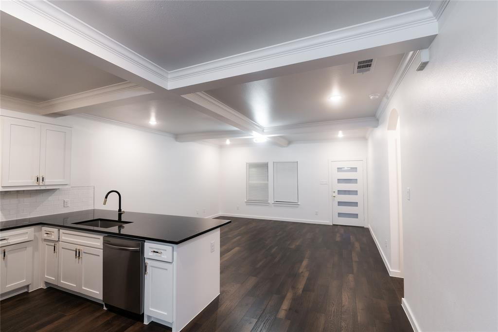 839 Southwest 7th Street Cooper, TX 75432 - Photo 4 of 21 Kitchen with dark countertops, dishwasher, a sink, visible vents, and a peninsula