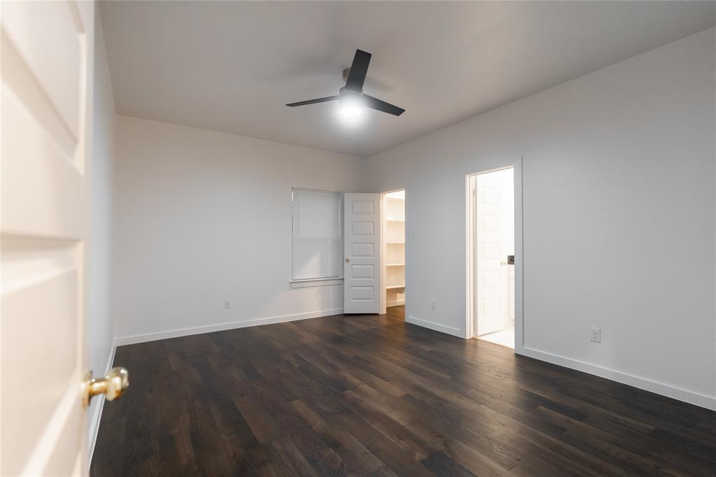 839 Southwest 7th Street Cooper, TX 75432 - Photo 5 of 21 Unfurnished bedroom featuring baseboards, ceiling fan, and dark wood-type flooring