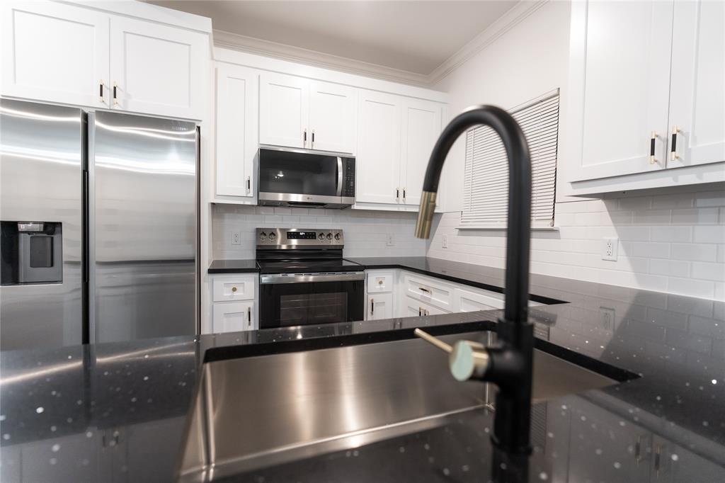 839 Southwest 7th Street Cooper, TX 75432 - Photo 7 of 21 Kitchen with appliances with stainless steel finishes, dark countertops, crown molding, and backsplash
