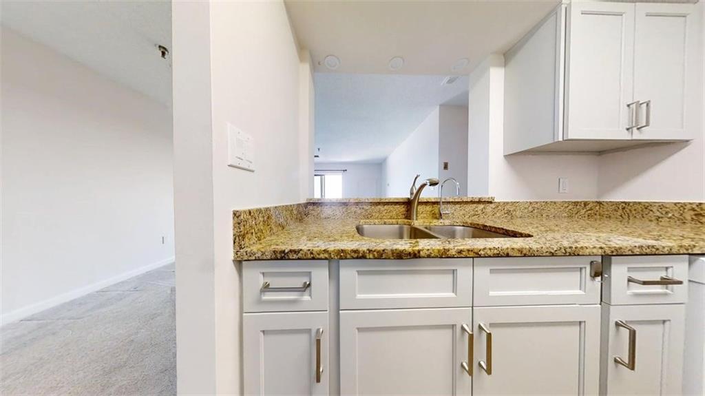 300 Johnson Ferry Road, Unit B805 Sandy Springs, GA 30328 - Photo 16 of 31 a kitchen with granite countertop cabinets and white appliances