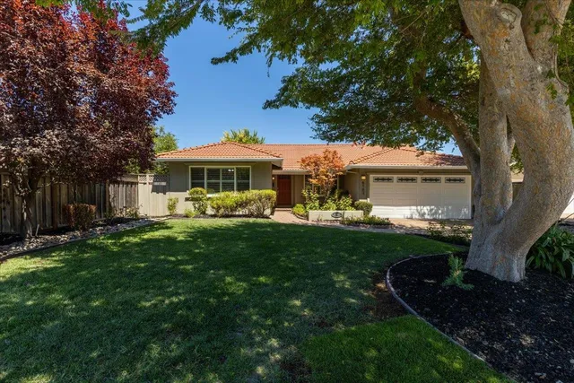 a view of a house with backyard and sitting area