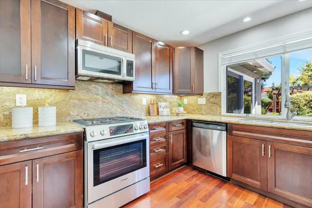 a kitchen with granite countertop cabinets stainless steel appliances and a sink