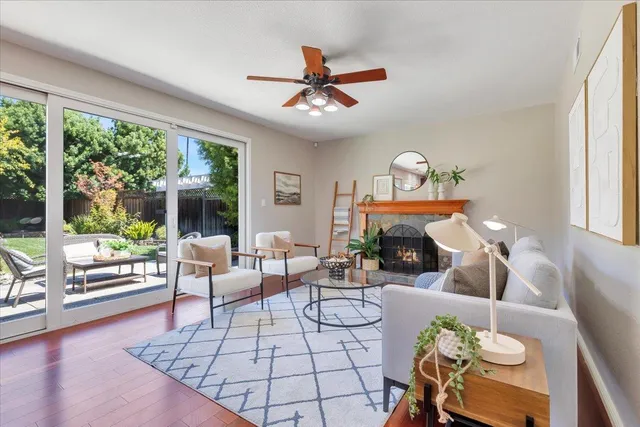 a living room with fireplace furniture and a large window