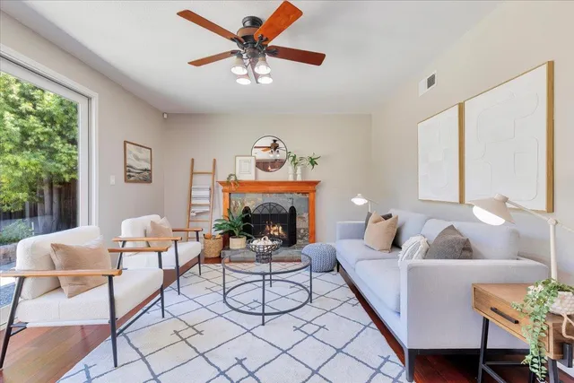 a living room with furniture a fireplace and a large window