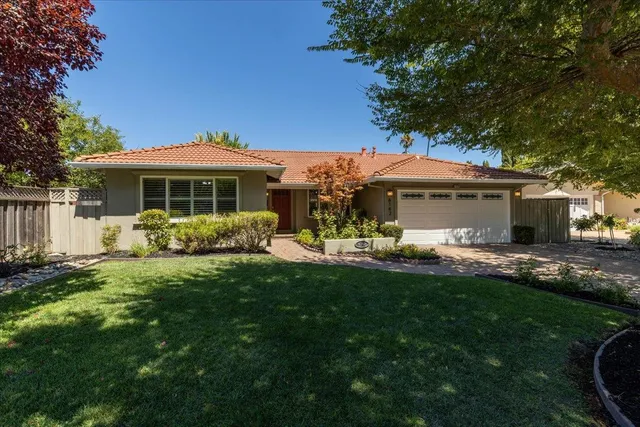 a front view of a house with a garden