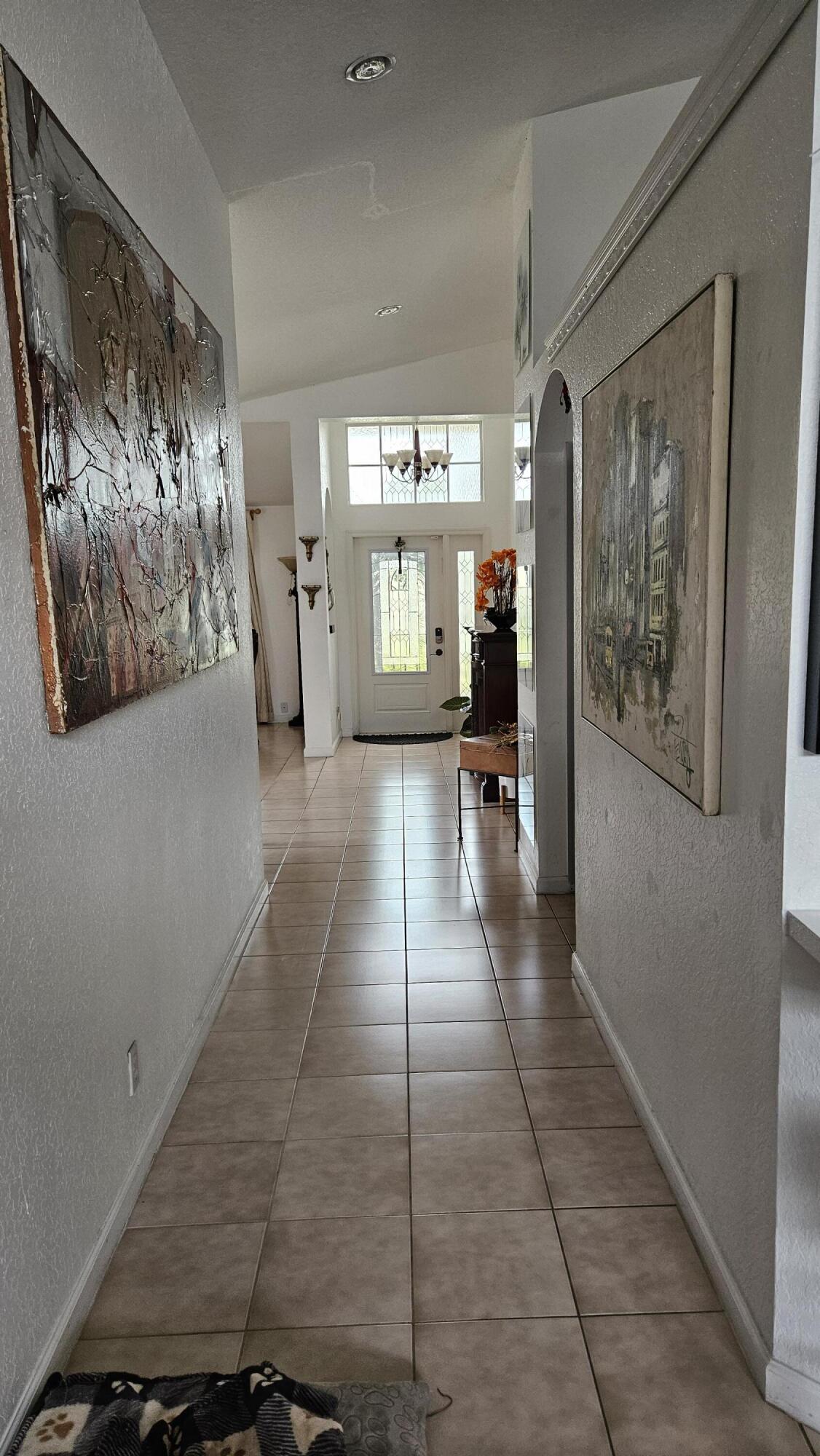 1768 Sawgrass Circle Greenacres, FL 33413 - Photo 18 of 40 a hallway with wooden floor and windows