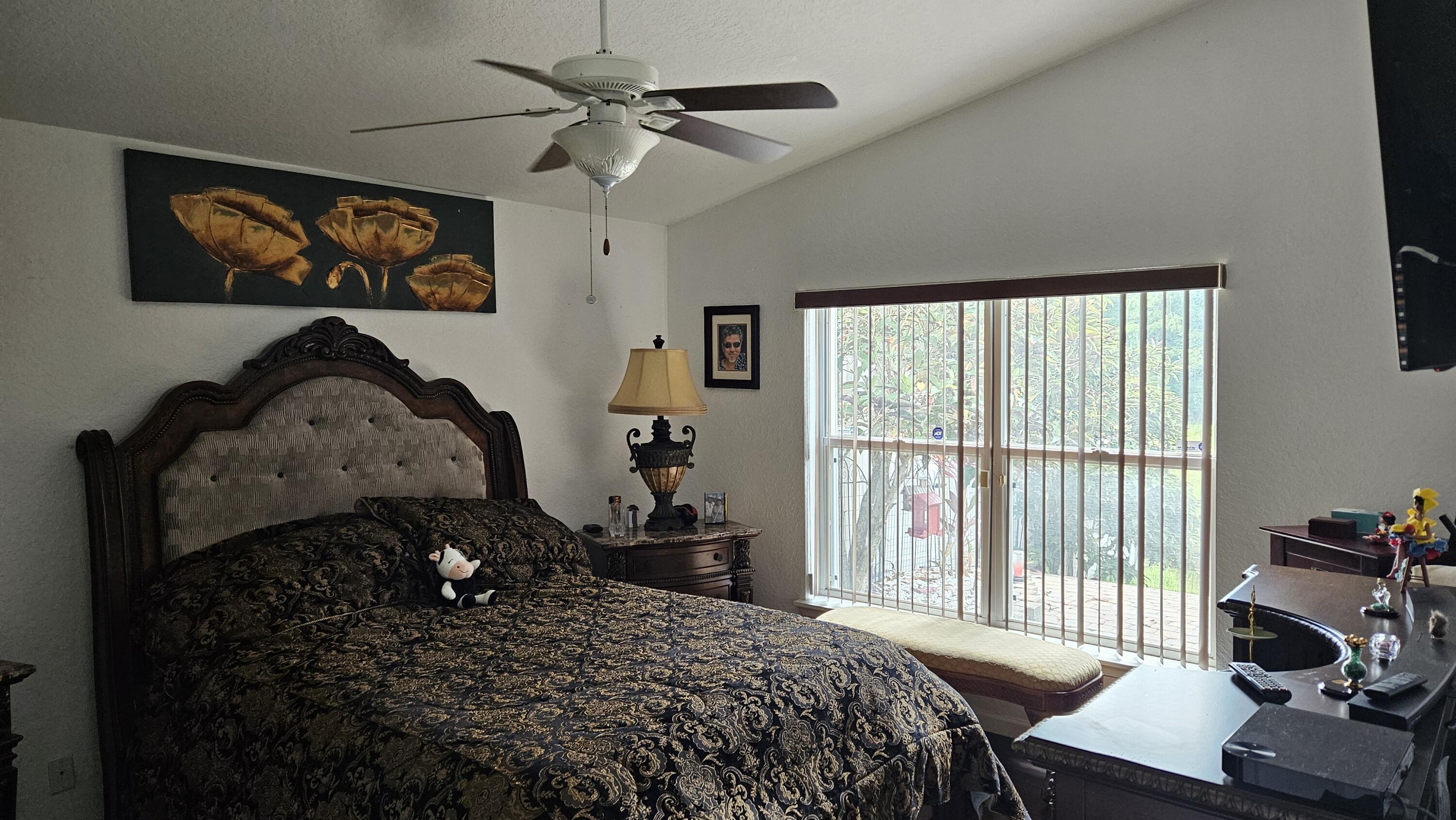 1768 Sawgrass Circle Greenacres, FL 33413 - Photo 24 of 40 a bedroom with a bed and a large window