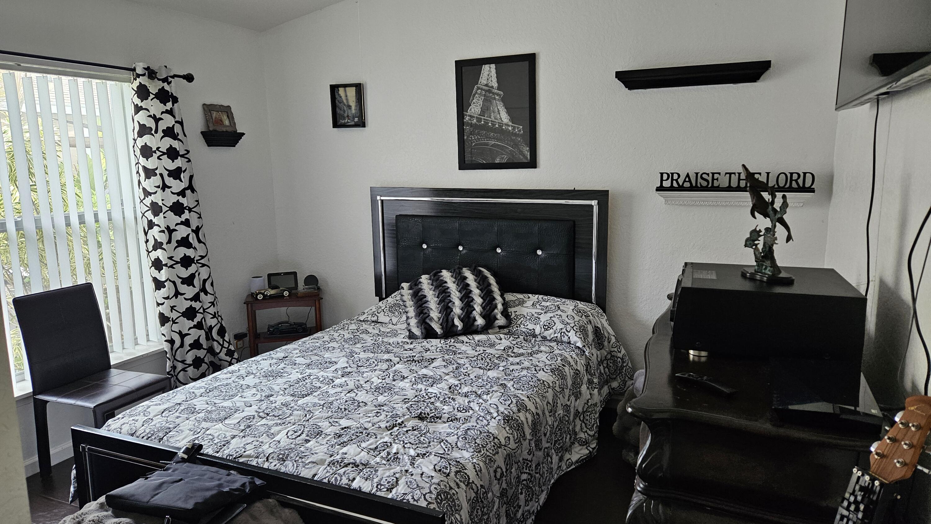 1768 Sawgrass Circle Greenacres, FL 33413 - Photo 27 of 40 a bedroom with a bed and a chair