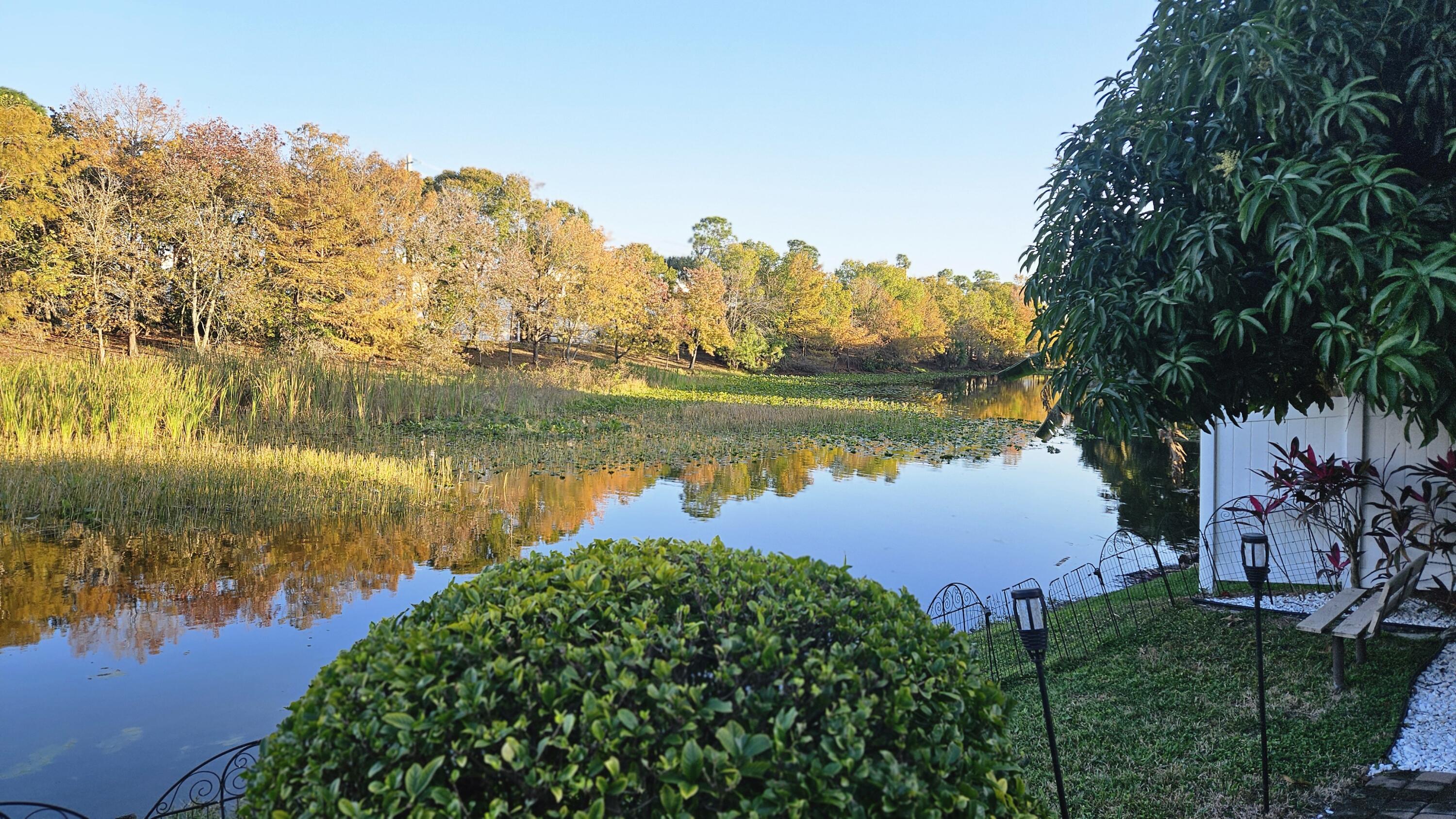 1768 Sawgrass Circle Greenacres, FL 33413 - Photo 4 of 40 a view of a lake with houses in the back