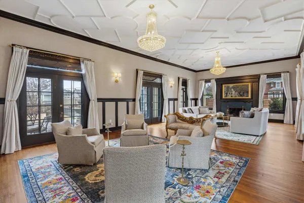 a living room with furniture a chandelier and a large window