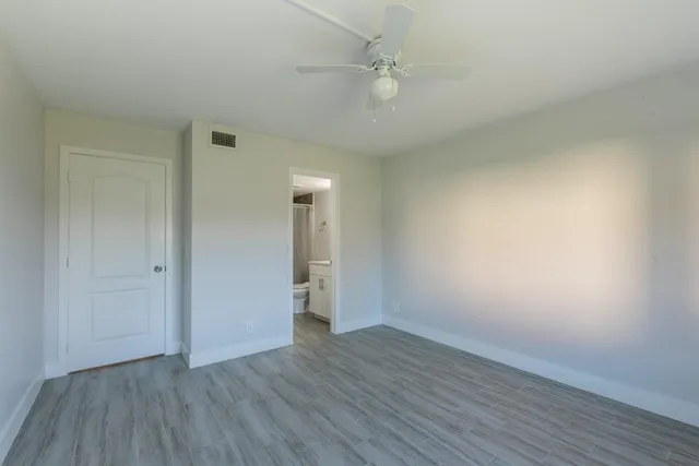 a view of an empty room with wooden floor