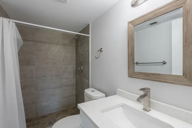 a bathroom with a sink a toilet and shower