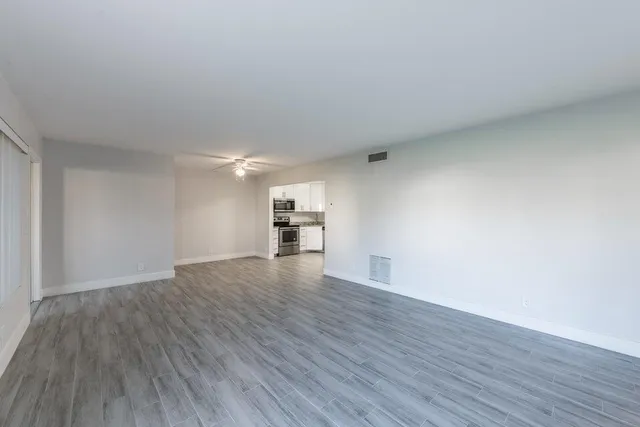 a view of empty room with wooden floor
