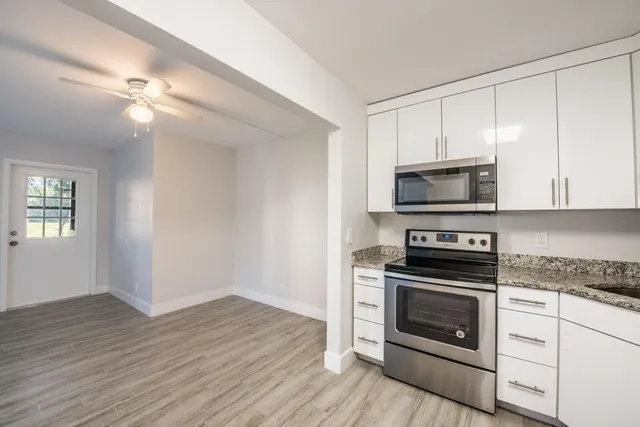 a kitchen with white cabinets and stainless steel appliances