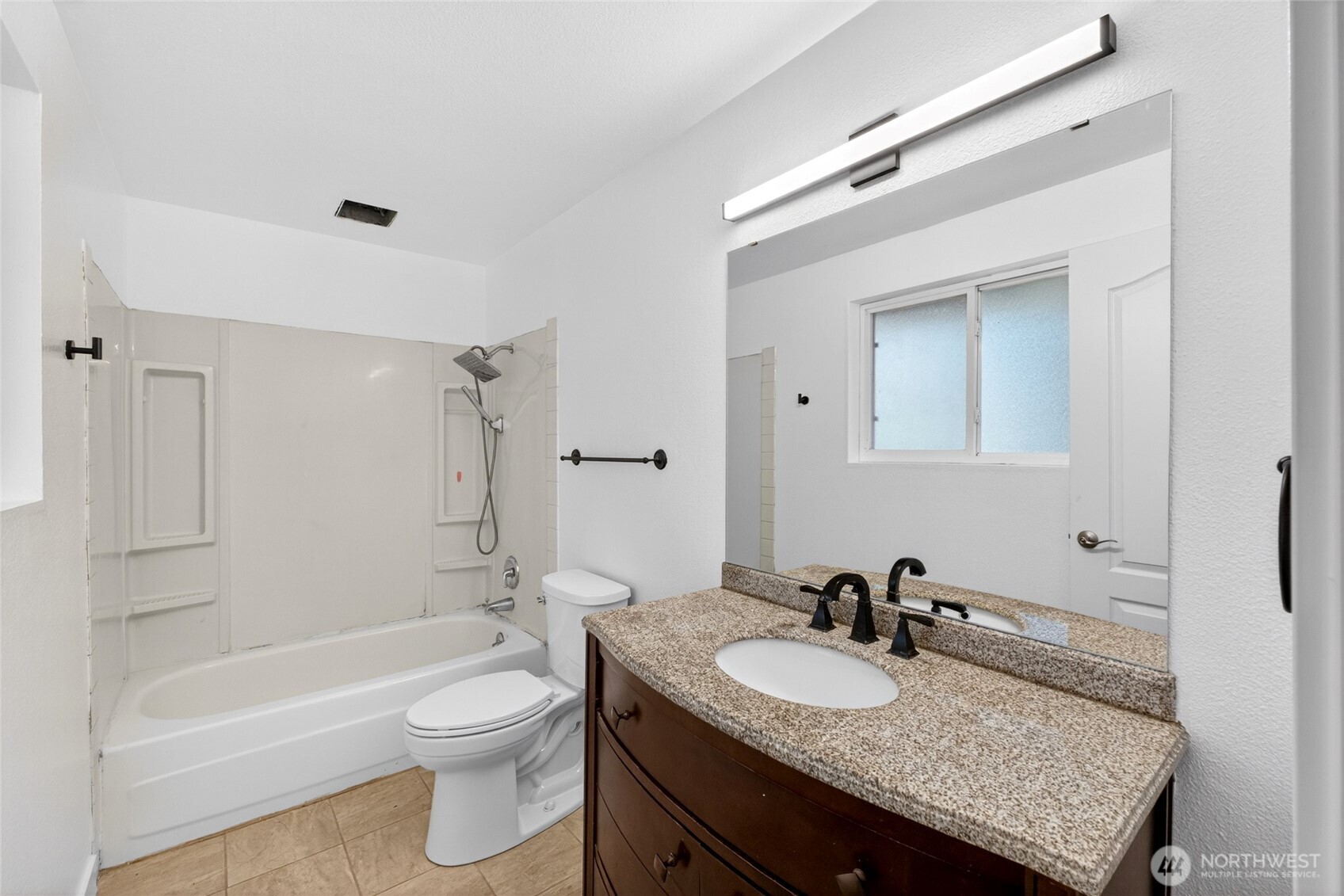19010 63rd Street East Lake Tapps, WA 98391 - Photo 11 of 32 a bathroom with a granite countertop sink toilet a mirror and bathtub