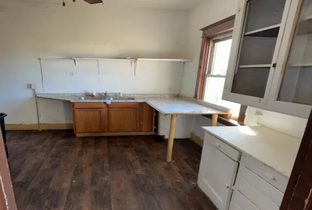 a kitchen with a sink cabinets and wooden floor