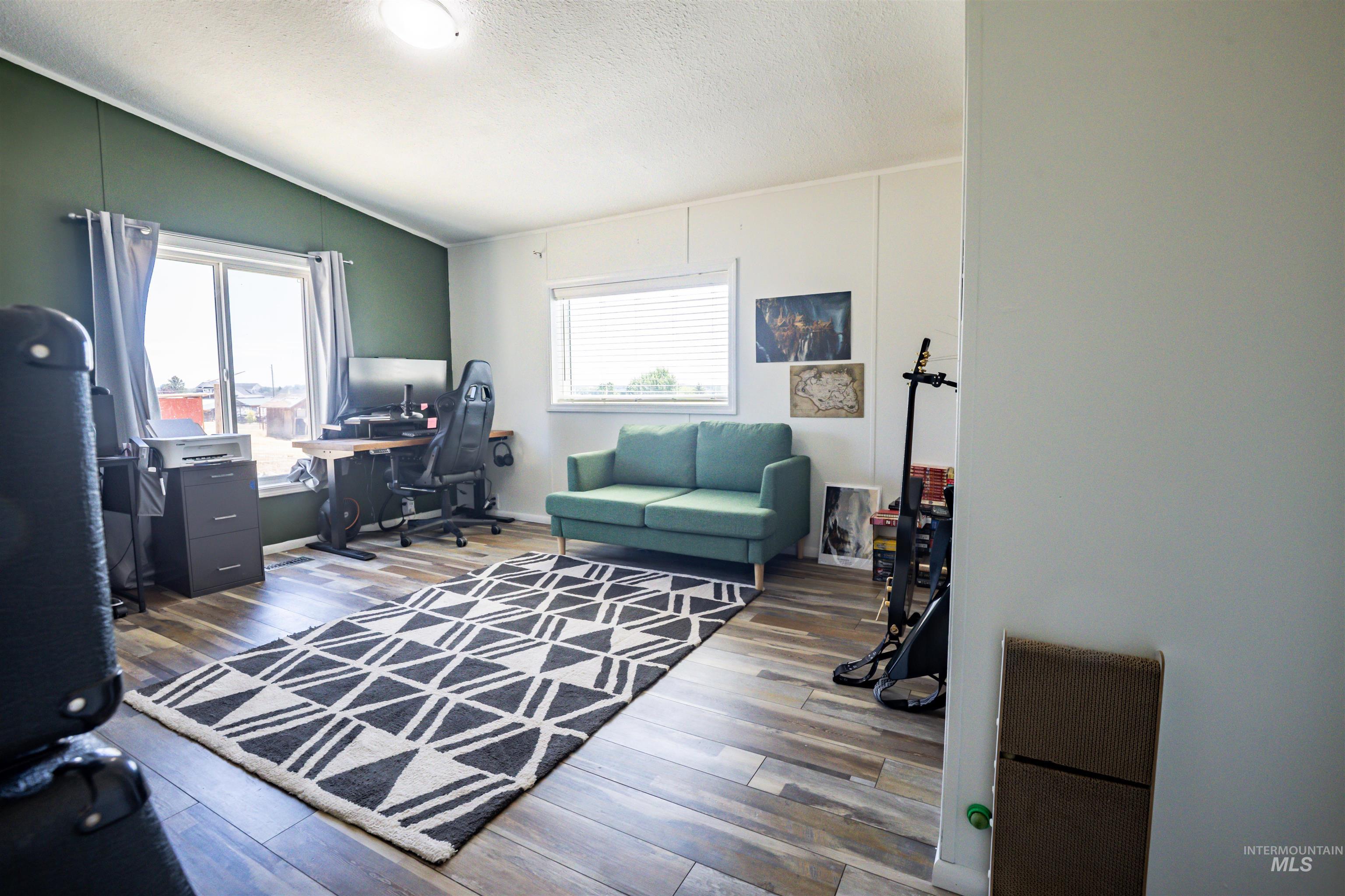 23904 Southview Lane Middleton, ID 83644 - Photo 25 of 29 Spacious room featuring wood-finish flooring, white walls, and a contrasting accent wall with a large window