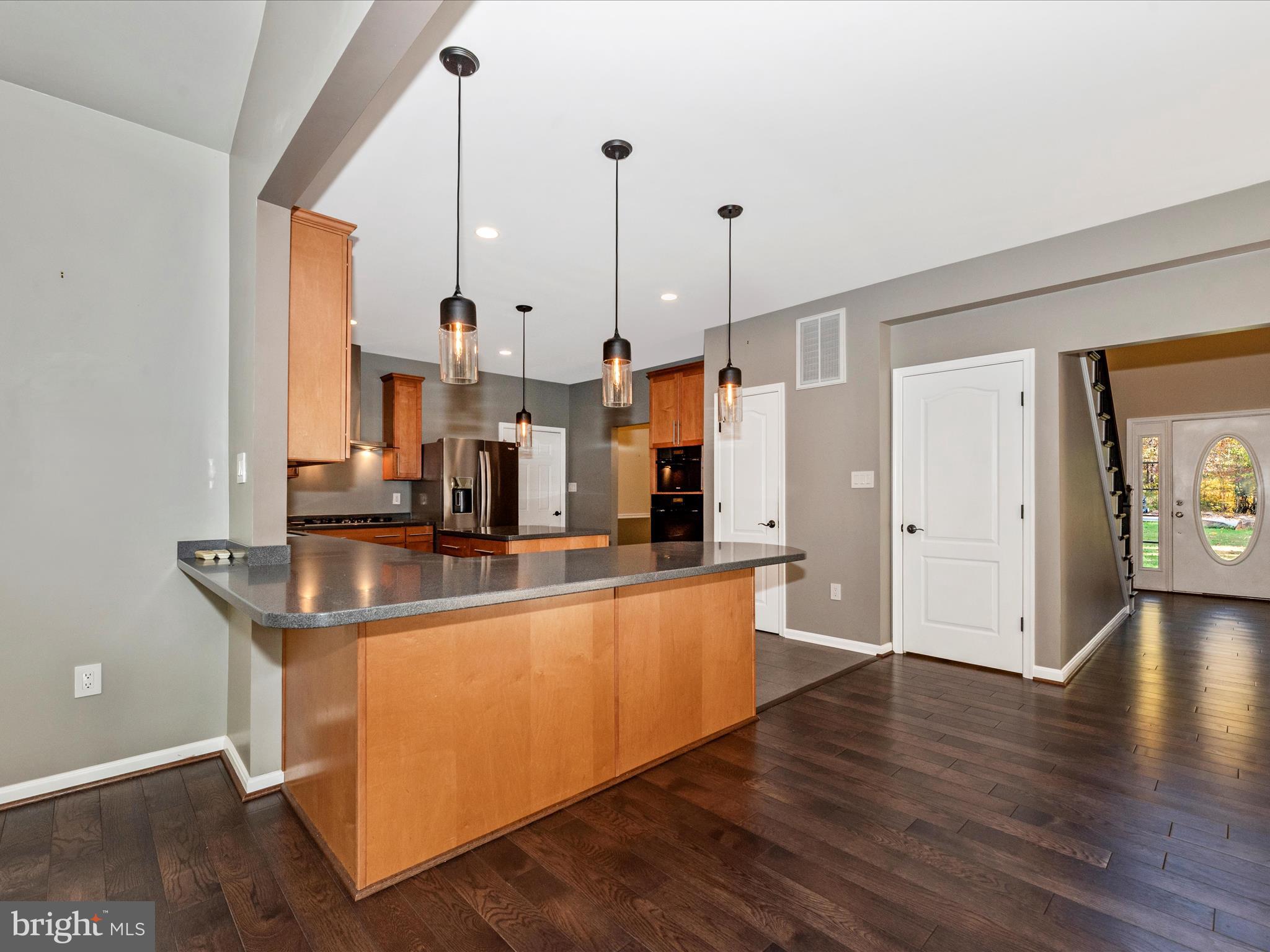 10027 Pine Tree Road Woodsboro, MD 21798 - Photo 16 of 81 a kitchen with stainless steel appliances granite countertop a sink a stove and a wooden floor