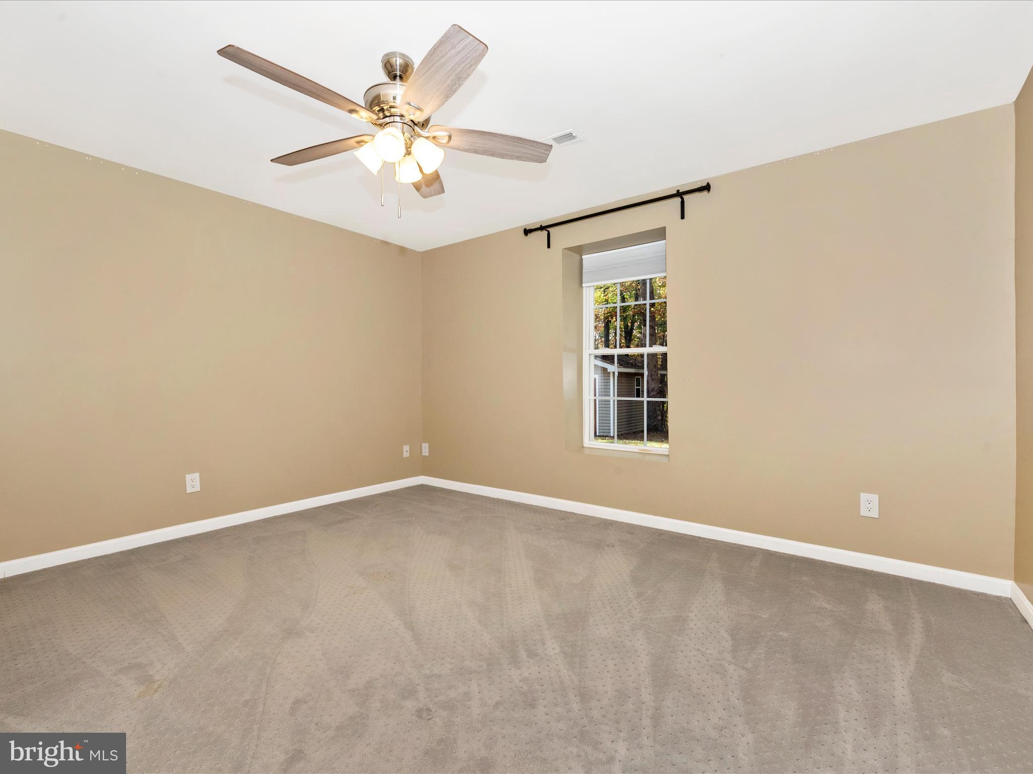 10027 Pine Tree Road Woodsboro, MD 21798 - Photo 64 of 81 a view of an empty room with a ceiling fan and a window