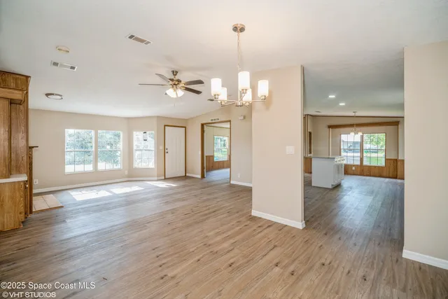 a view of a room with wooden floor and a kitchen