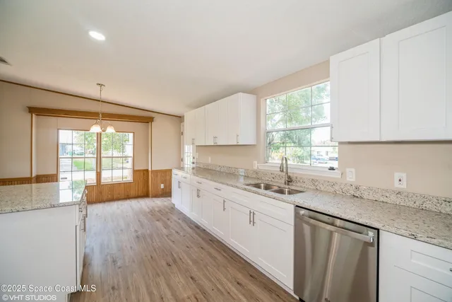 a kitchen with stainless steel appliances granite countertop a sink a stove cabinets and wooden floor