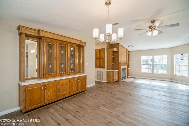 a view of a kitchen with stainless steel appliances wooden floor and chandelier