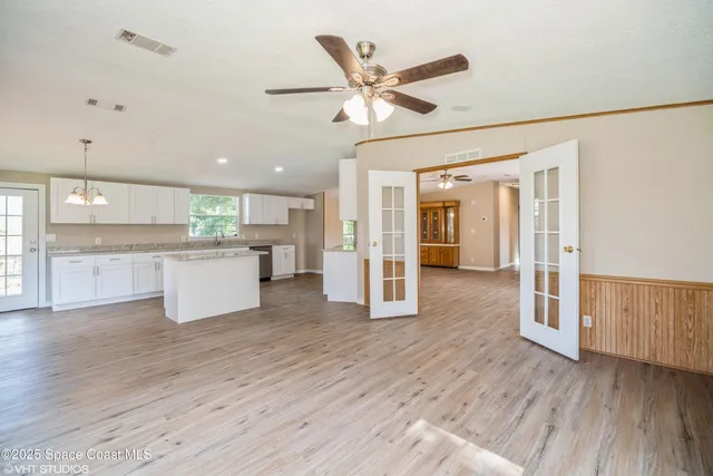 a view of a kitchen with wooden floor and a ceiling fan