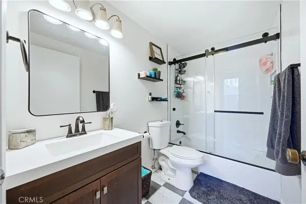 a bathroom with a sink a toilet a mirror and shower