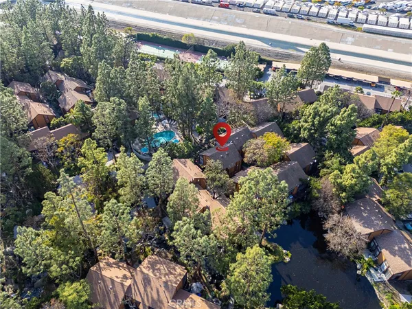 an aerial view of residential houses with outdoor space and trees all around