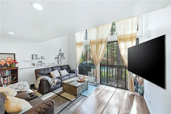 a living room with furniture tv and a floor to ceiling window