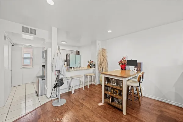 a room with stainless steel appliances kitchen island granite countertop furniture and a wooden floor
