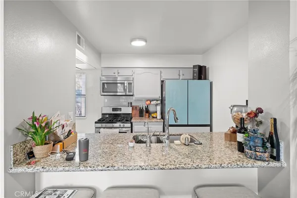a kitchen with stainless steel appliances granite countertop a stove and a sink