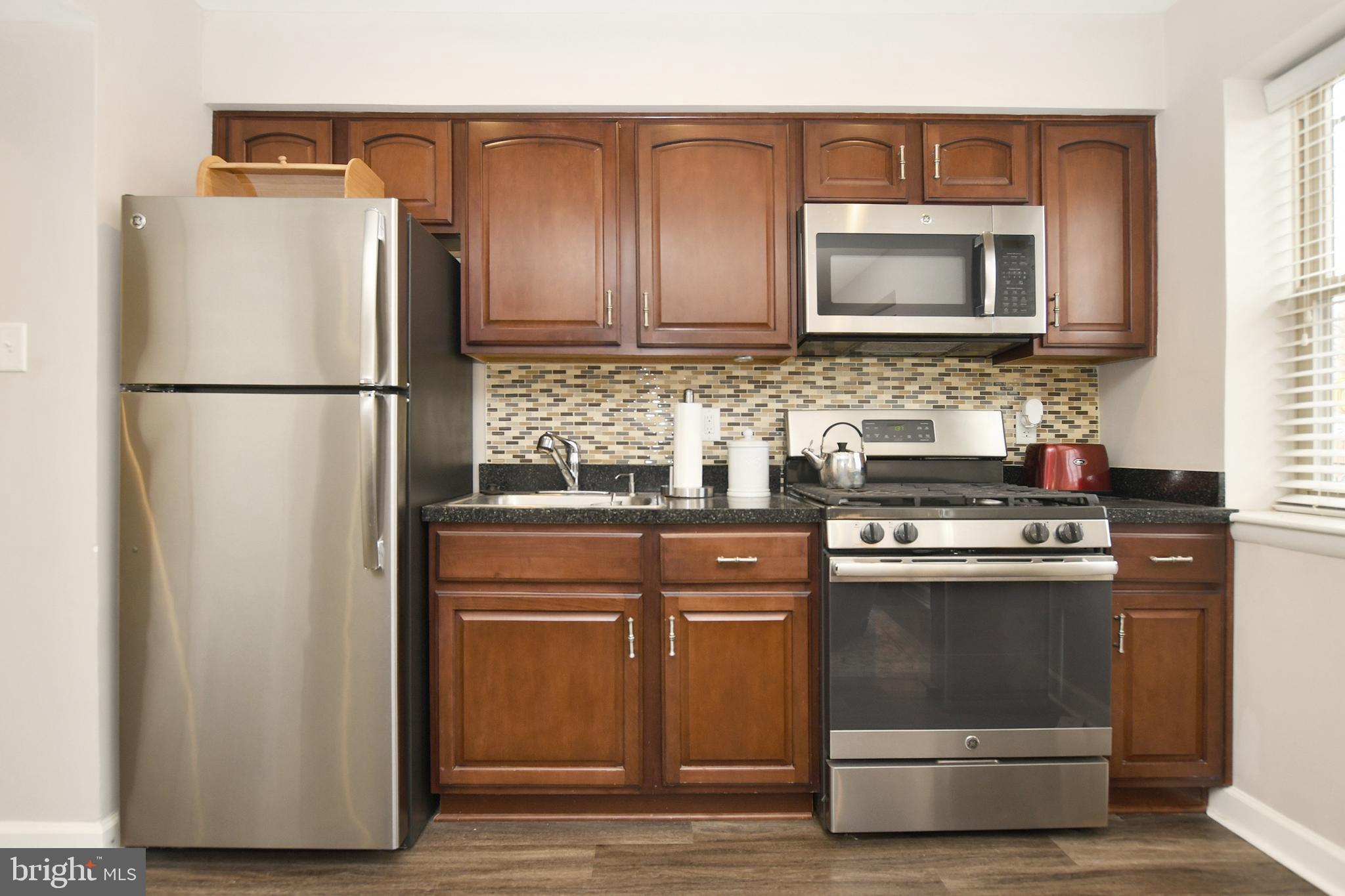 2900 Pomeroy Road Southeast, Unit 104 Washington, DC 20020 - Photo 11 of 19 a kitchen with stainless steel appliances a refrigerator stove and microwave