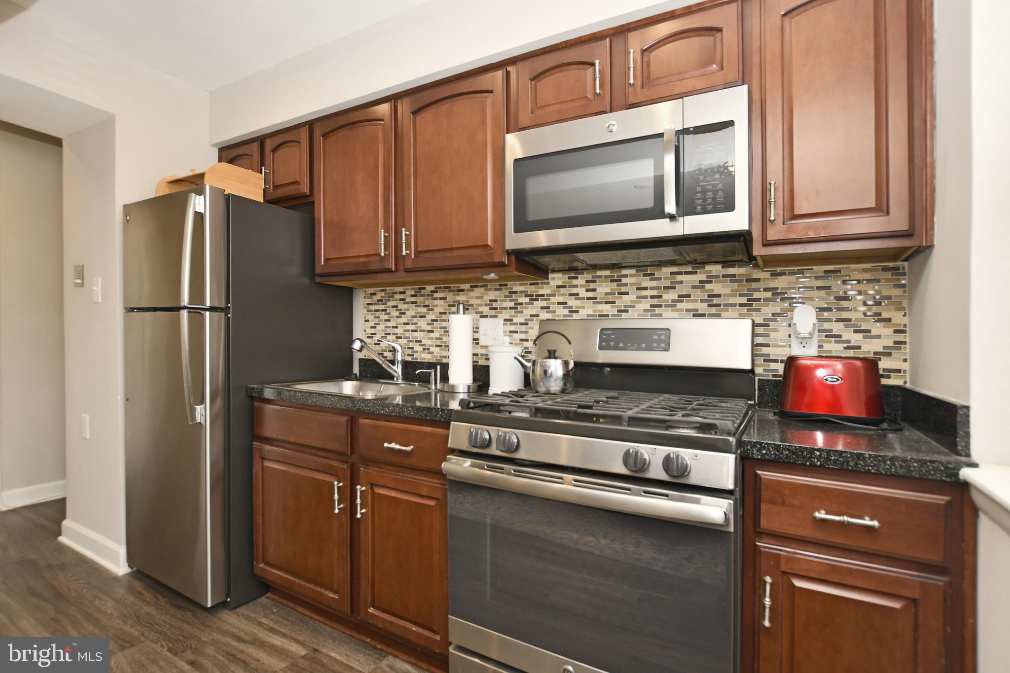 2900 Pomeroy Road Southeast, Unit 104 Washington, DC 20020 - Photo 12 of 19 a kitchen with stainless steel appliances granite countertop a refrigerator stove and microwave
