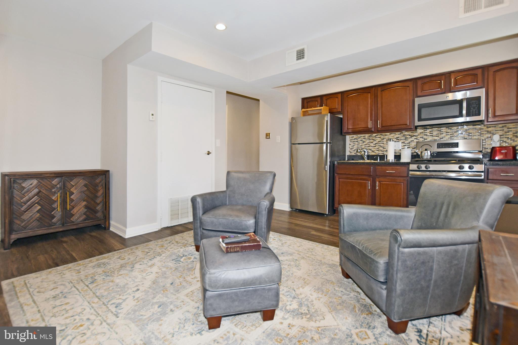 2900 Pomeroy Road Southeast, Unit 104 Washington, DC 20020 - Photo 6 of 19 a living room with furniture a flat screen tv and kitchen view