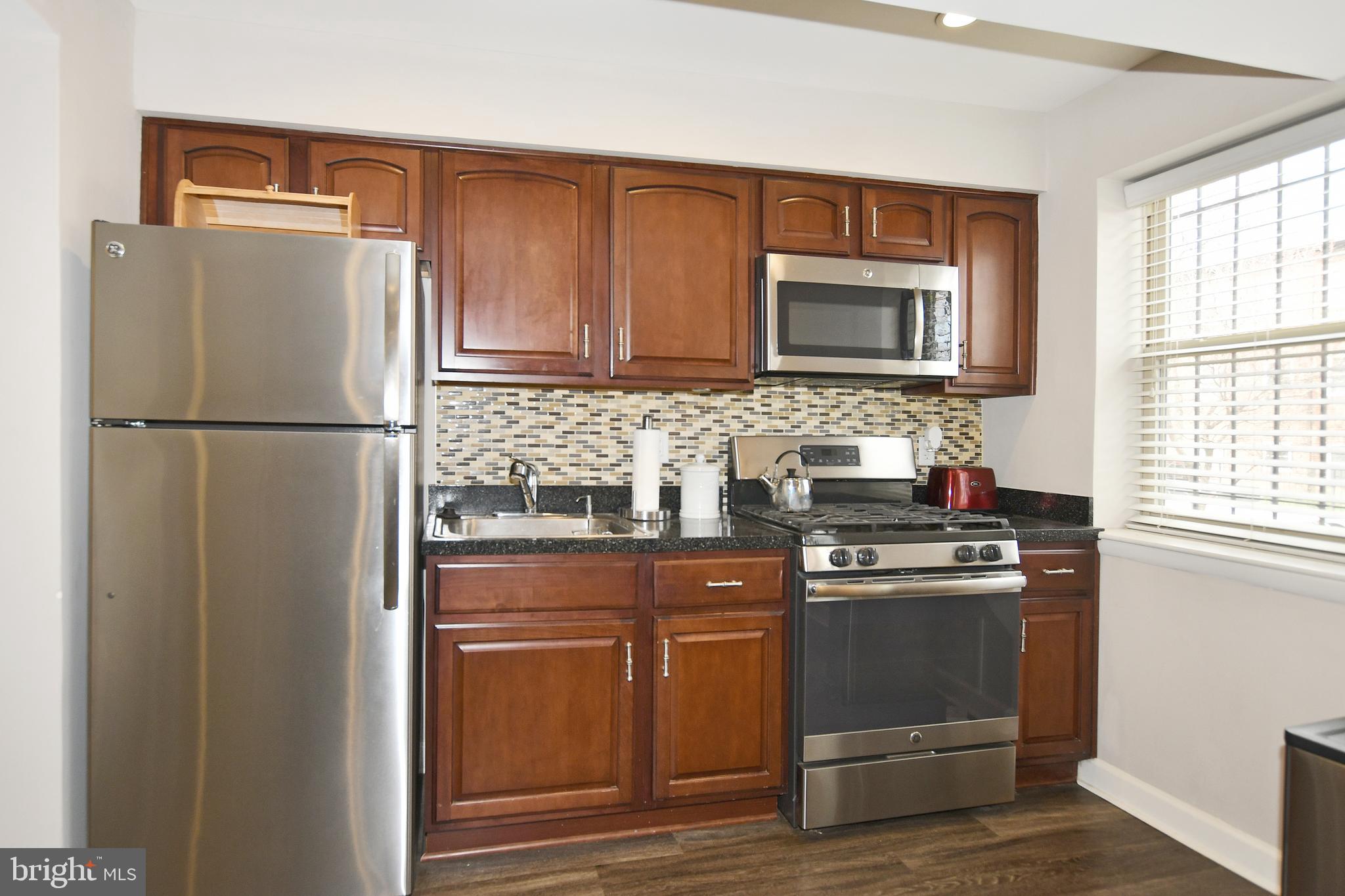 2900 Pomeroy Road Southeast, Unit 104 Washington, DC 20020 - Photo 10 of 19 a kitchen with appliances a refrigerator and a sink