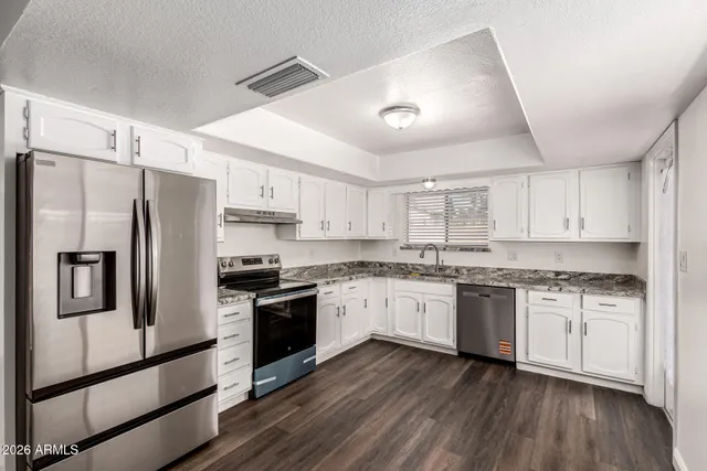 a kitchen with granite countertop stainless steel appliances and wooden cabinets