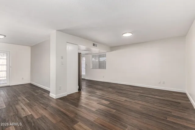 a view of an empty room with wooden floor