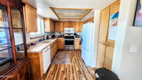 a kitchen with sink a refrigerator and wooden floor