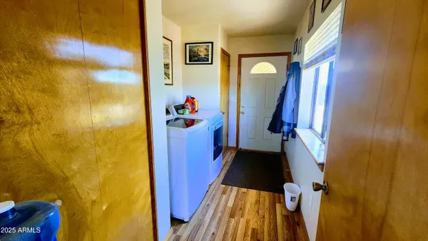 a view of a hallway with wooden floor and stairs