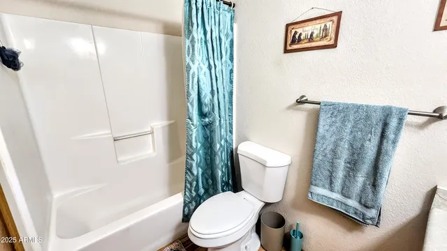 a white toilet sitting next to a bath tub and a shower