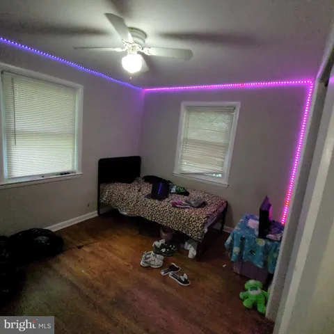 a bed sitting in a bedroom next to a window and a wooden floor