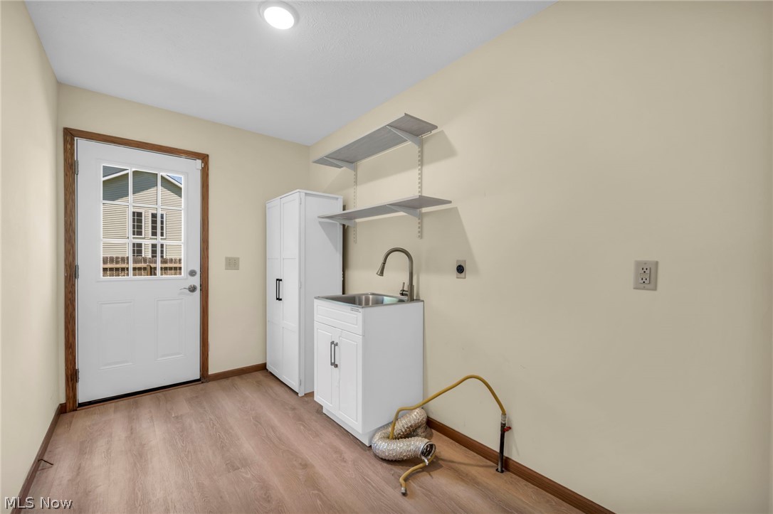 9842 Johnnycake Ridge Road Mentor, OH 44060 - Photo 28 of 40 Utility room featuring wood-finish flooring and a white paneled door with divided lite windows