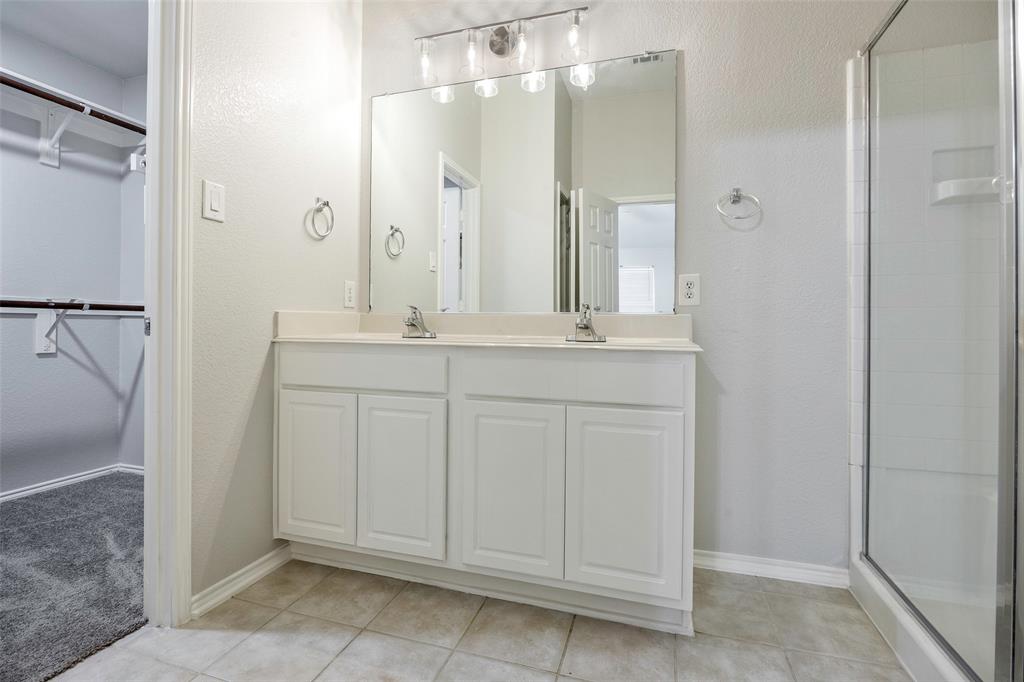 3603 Cottonwood Road Melissa, TX 75454 - Photo 13 of 27 Bathroom with a textured wall, double vanity, a spacious closet, a stall shower, and light tile patterned flooring